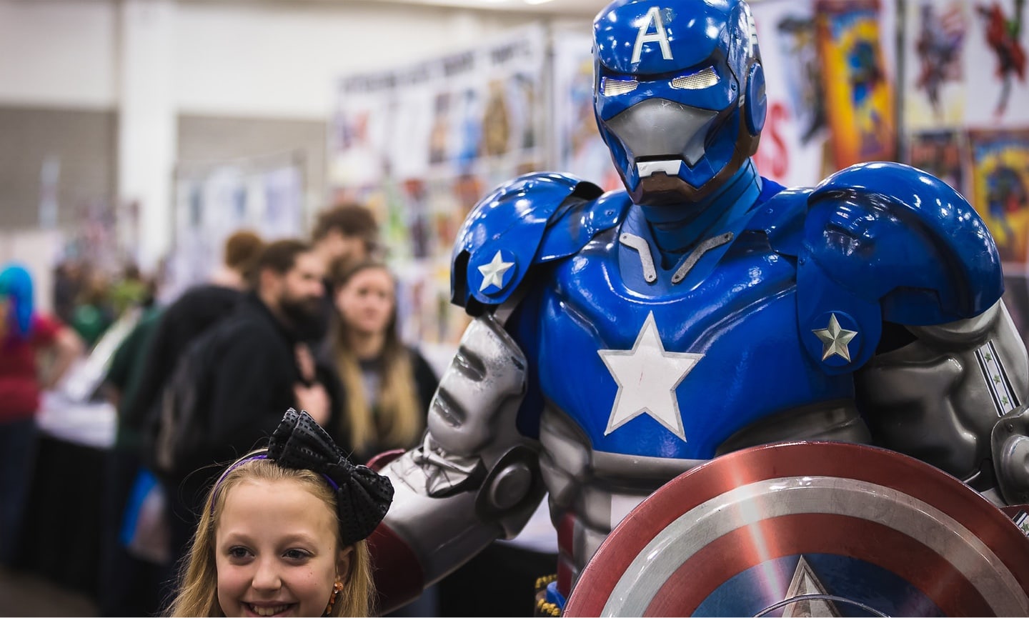Little girl with man using captain America costume at Wizard World event