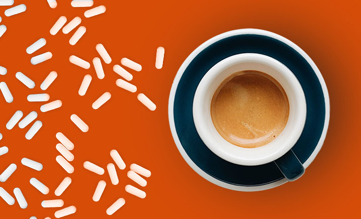 Coffee cup and pills on orange background