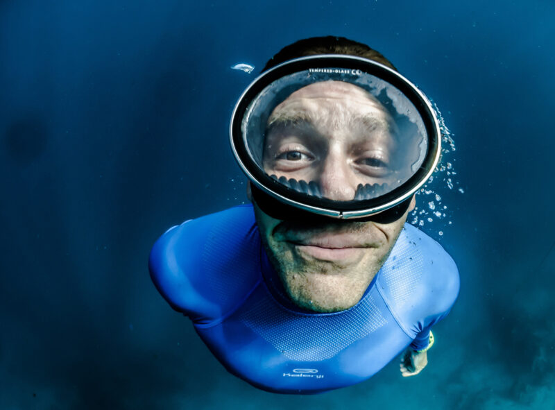 man with mask swimming underwater